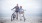 elderly couple walk their bicycles on a beach